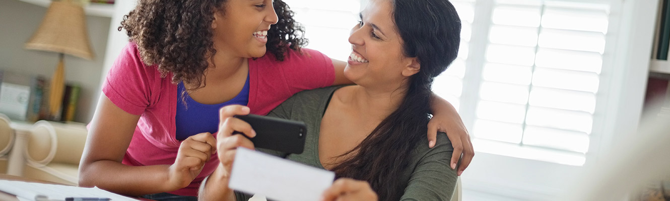 Mother and daughter taking a picture of a check for RDC. 